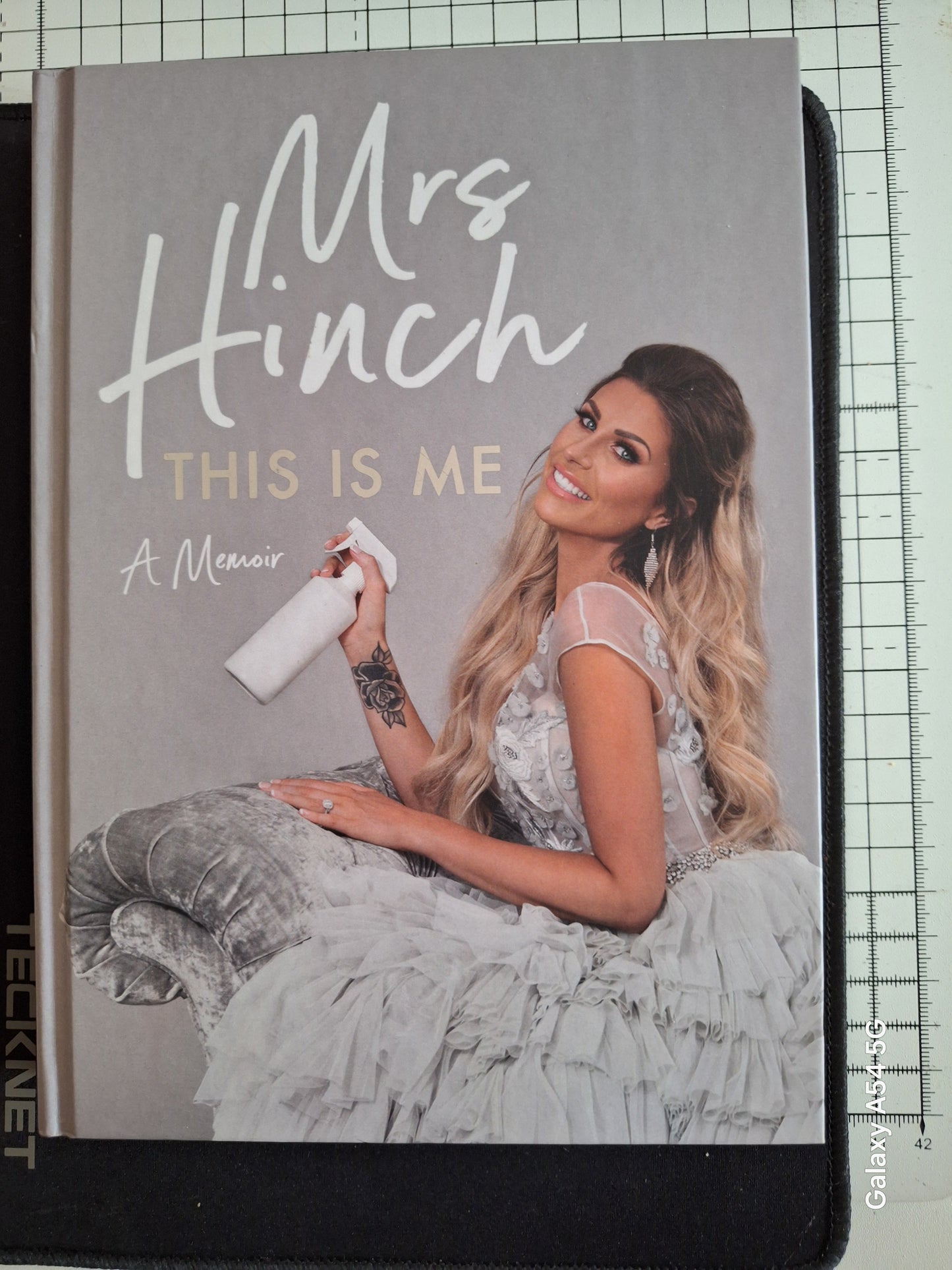 Mrs Hinch memoir book cover featuring Mrs Hinch in a white dress holding a spray bottle
